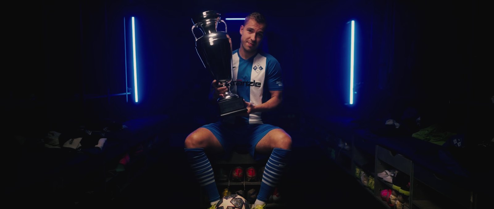 Standbild aus dem Imagefilm für den FV Illertissen: Spieler mit Pokal in der Kabine